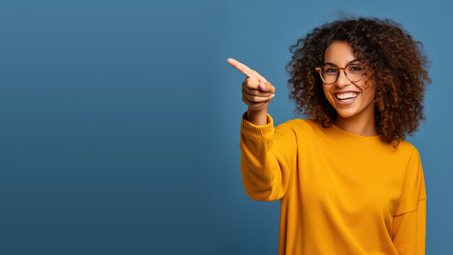 Beautiful young black woman pointing up to copy space and smiling, happy, Pretty girl act like satisfied at the product, use for advertising , isolated on blue background