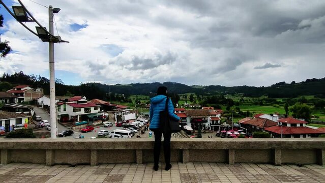 young woman looking at a beautiful landscape with mountains and sky