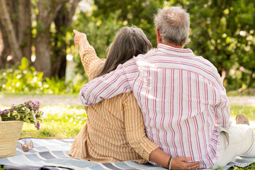 Happy senor european man and lady sit on plaid, enjoy romantic date, picnic
