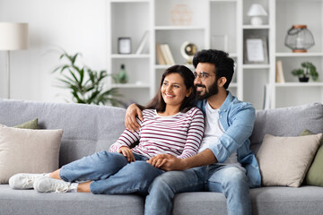 Loving eastern millennial man and woman cuddling at home