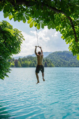 Person jumping in the crystal clear water of lake bled