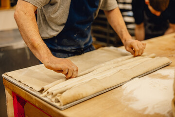 baker lining up baguettes for proving before being baked professional kitchen couche