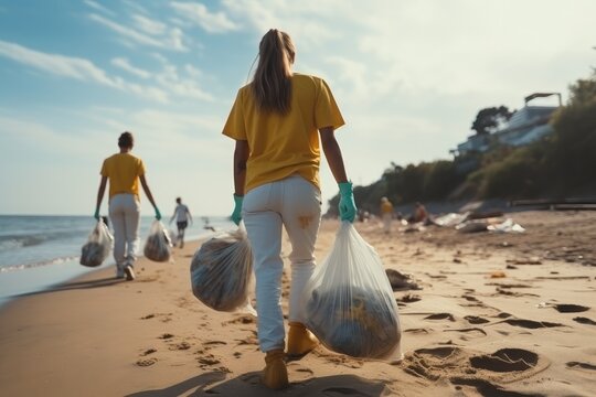 A woman collects and puts used plastic bottle into a trash bag, Clearing, Pollution, Ecology and plastic concept.