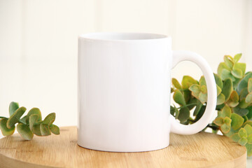 Mock up of coffee cup at green blur eucalyptus