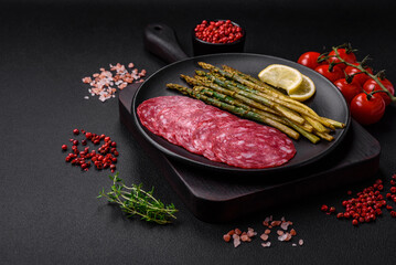 Delicious nutritious breakfast consisting of sliced sausage, asparagus, salt, spices and herbs