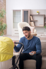 Young man looking after newborn at home
