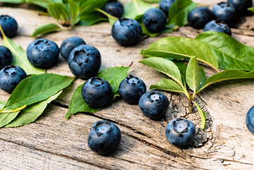 Blueberries lie on a wooden surface in a plate. Blueberries scattered on a wooden table