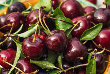 Cherry berries lie in a clay plate on a wooden table. Cherry. Berries