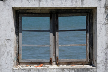 Fototapeta na wymiar Looking out the window of an abandoned building in Lisbon, Portugal, during a sunny day