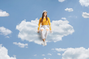 Young trendy female sitting on a cloud up in the sky