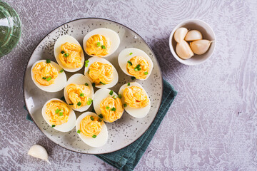 Eggs filled with a mixture of yolk, cheese, garlic and mayonnaise on a plate top view