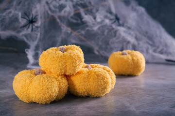 Halloween card handmade knitted pumpkins on the background of cobwebs and spiders