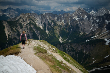 Woman hiking on a mountain-top trail in the Austrian Alps