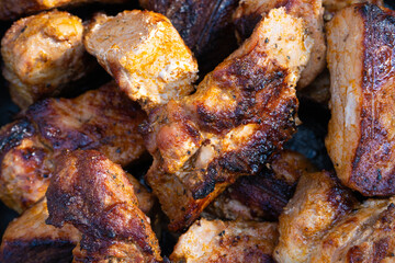 Pieces of grilled, barbeque kebab close-up. Pattern made of fried meat pieces with crispy crust, top view