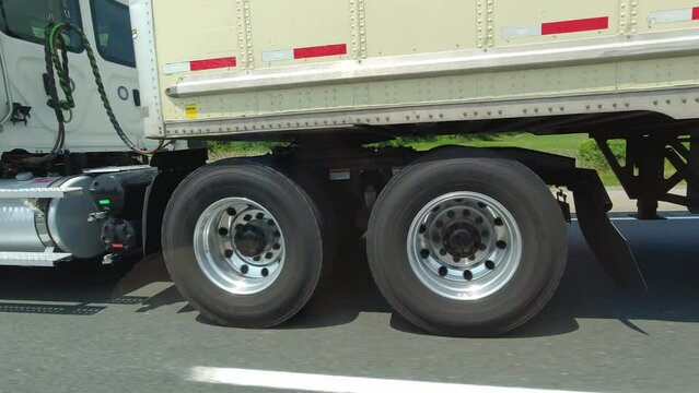 Close up of cargo truck wheels and tires. Passing semi truck on highway. Freight heavy duty vehicle. Canadian commercial industrial tracking, transportation and delivery.