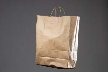 Packet for shopping. Wrinkled paper bag. Recyclable packaging concept. Paper bag for rejection of plastic. Kraft bag isolated on gray background. Packet for going to grocery store.