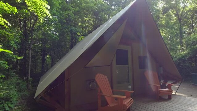 Point Pelee camping site with cabin tent under canopy of the Carolinian Forest in the park. Accommodation shelter for tourists and visitors during vacation. Site with barbeque fire pit. Campground.