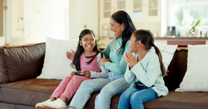 Mom, children gaming and winning a video game, competition or girl playing esports on living room, couch or quality time on sofa. Happy, mother with girls and child in celebration of win in e sports