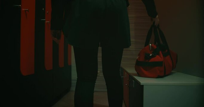 dark silhouette of sportswoman walking in locker room before training, rear view of hips, 4K, Prores