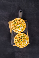 Vegan Round Corn waffles. On a wooden board. On a linen napkin. Dark gray background. Top view	
