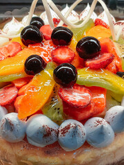 Delicious sweet cake with cream and glazed berries and fruits on top
