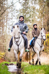 Horse riding, Way of st James in Fragas do Eume, Galicia. Hispanic pilgrim mid couple equitation