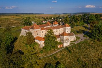 Obraz premium Scenic aerial view on medieval castle on lake shore. Location place: Svirzh, Ukraine. View from flying drone quadcopter.