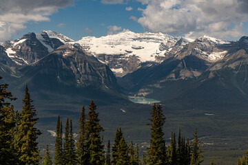 Wilderness views in Banff National Park during summer time with snow capped mountains on a blue sky, clouds day. Beautiful nature in Alberta, British Columbia