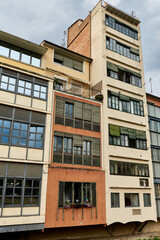 Fototapeta premium Lgbt signs on a window of appartment of residential building. Rainbow flag LGBTQ community support symbol on a balcony in Barcelona, Spain, Europe. LGBT Rainbow Sign Balcony, Old Town.