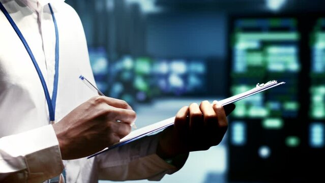 Close up of worker writing info on supercomputer cybersecurity dangers arising due to unsecured network connections. Technician making sure supercomputer farm is invulnerable to virus attacks