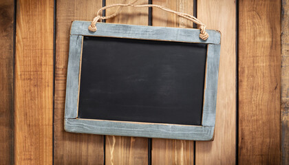 Vintage slate chalk board hanging on wooden background