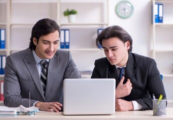 Obraz premium Two young employees working in the office
