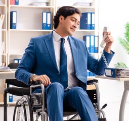 Male employee in wheelchair working at the office