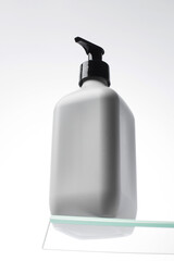 A mock-up of a white dispenser with cosmetics on the shelf. Shower gel, shampoo. Skin care.