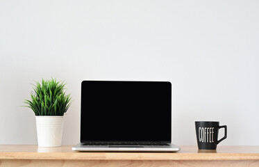 Fototapeta premium Digital Workspaces: A Sleek and Contemporary Office Setting with a Modern Laptop on Wood Table
