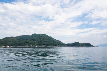 Plakat 京都府伊根町の街並みで、海辺にたたずむ古民家の風景は、伊根の舟屋と呼ばれています。