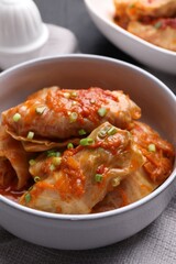 Delicious stuffed cabbage rolls cooked with homemade tomato sauce on table, closeup