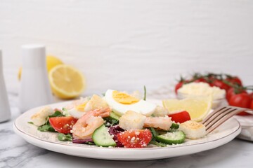 Delicious Caesar salad with shrimps on white marble table, closeup