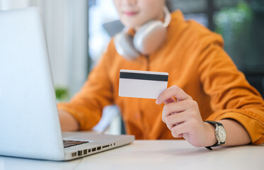 Woman holding credit card and using laptop computer. Online shopping, e-commerce, internet banking concept..