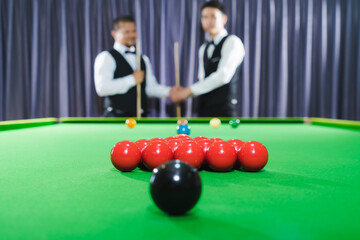 The contestants shake hands before the start of the game. Focus red snooker ball with noise