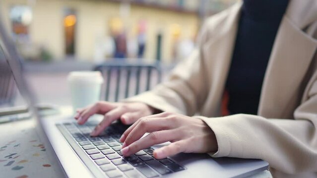 Asian businesswoman working corporate business on laptop computer at outdoor cafe in the city. Digital nomad freelance people working creative job from anywhere on device gadget with online network.
