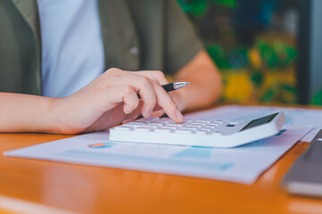 business person sitting at a desk at an office By using the calculator to work. Business Concept Analysis and Planning