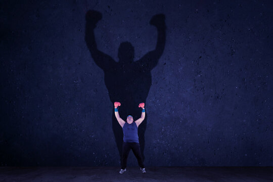 Overweight Man With Boxing Glove Raising Hands After Exercise