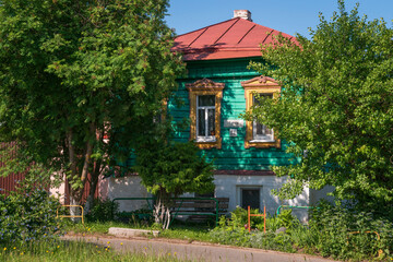 Fototapeta premium Russian traditional wooden house decorated with house carvings and a front garden on a sunny summer day, Suzdal, Vladimir region, Russia