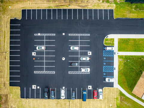 Aerial view of a partially filled new asphalt US parking lot.