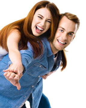 Smiling funny young couple. Portrait image of standing piggy back ride models in love studio concept, cut out over white background. Man and woman posing together.