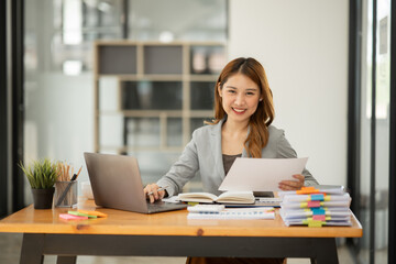 Obraz na płótnie Canvas Asian business woman looking at financial documents