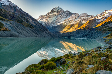 The glacial alpine lake in the Hooker valley sitting at the base of the tallest peaks of the Southern alps in the Hooker valley track