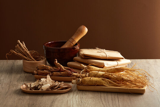 Front view of ginseng roots on tray, rhizoma rhe and codonopsis pilosula displayed on wooden table. Healthy herbs. Advertisement scenes for traditional Chinese medicines