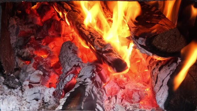Close-up of firewood burning in the fireplace, in the oven. Close-up of a burning campfire. Fire burns. Burning traditional big flame firewood. Cooking or baking in a wood-fired oven